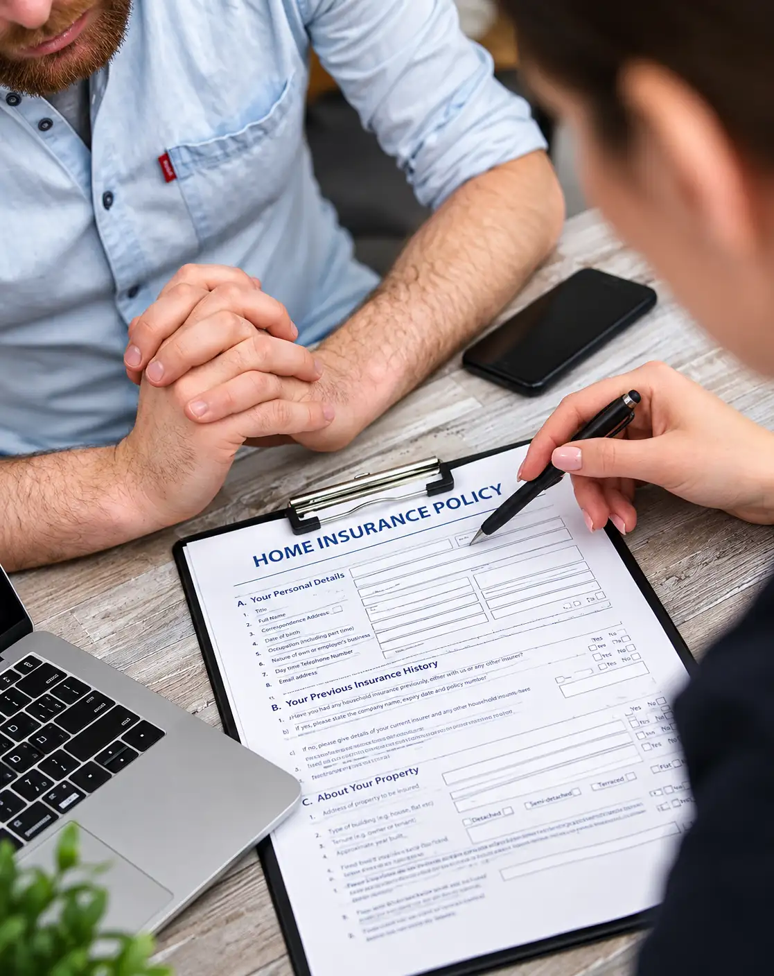 An adjuster reviewing a home insurance policy form with a homeowner